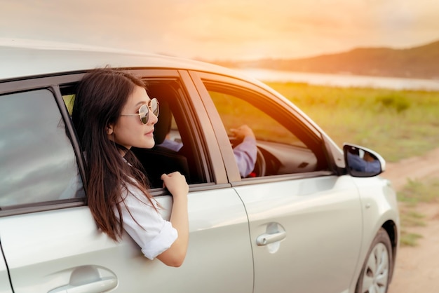 写真 車に座っている若い女性が目をそらしている