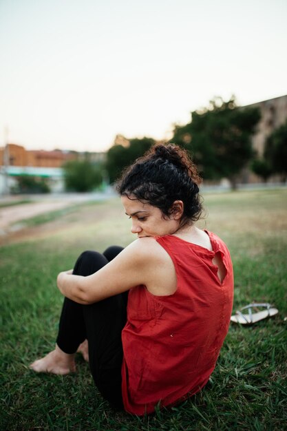 Photo young woman looking away while sitting on land