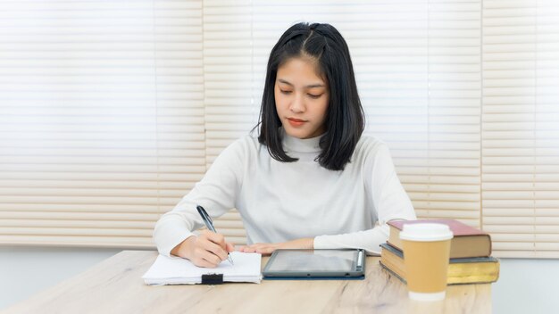 写真 テーブルに座っている若い女性が目をそらしている