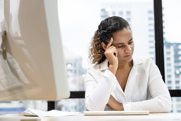 Photo young woman looking away while sitting on table