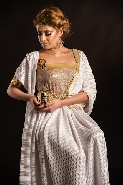 Young woman looking away while standing against black background