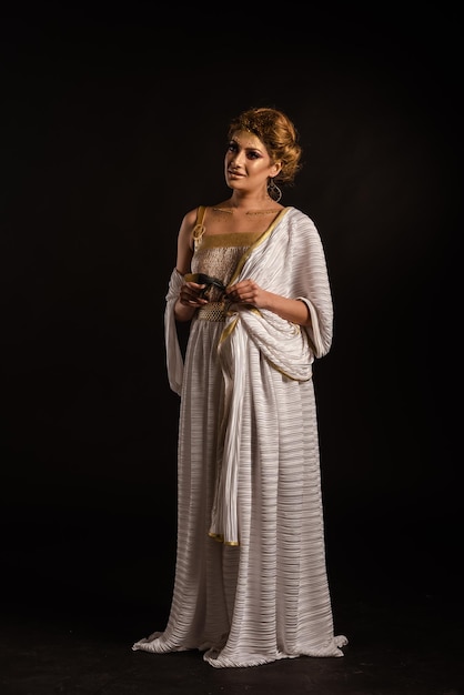 Young woman looking away while standing against black background