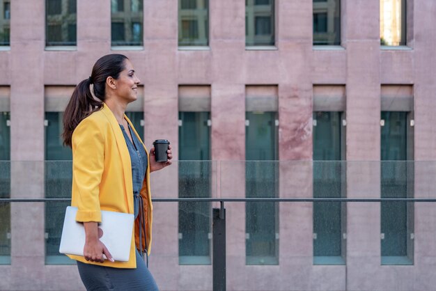 Photo young woman looking away while standing against building