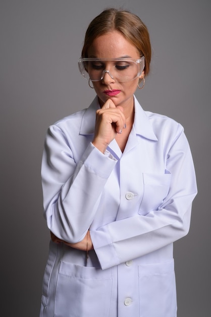 Photo young woman looking away while standing against gray background