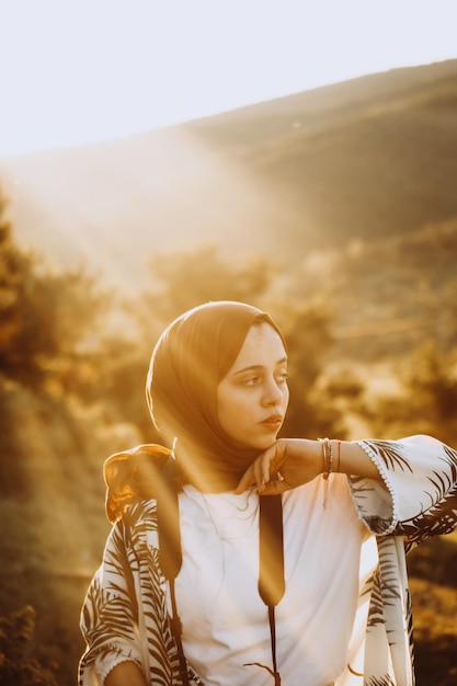 young woman looking away while standing against sky