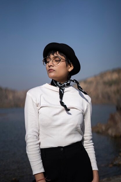 Photo young woman looking away while standing against sky