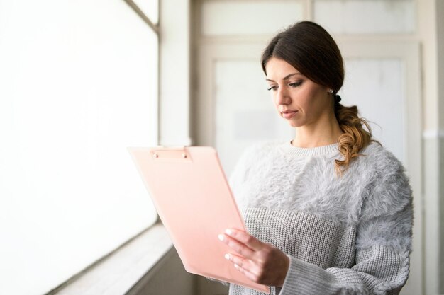 Photo young woman looking away while standing against wall