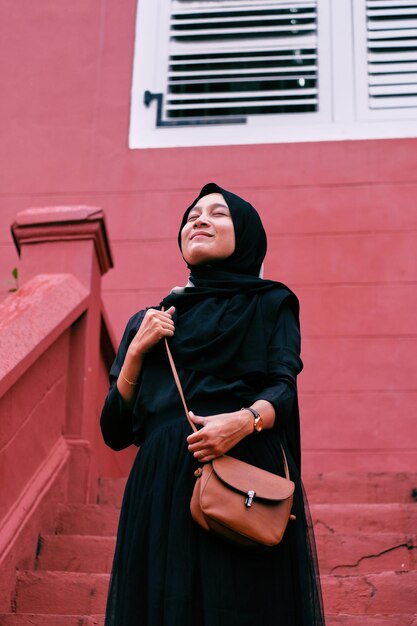 Photo young woman looking away while standing against wall