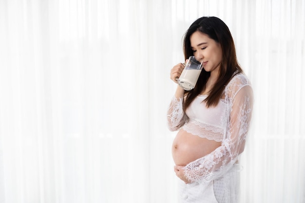 白い壁に寄りかかっている若い女性