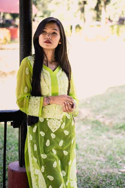 Photo young woman looking away while standing by railing at park