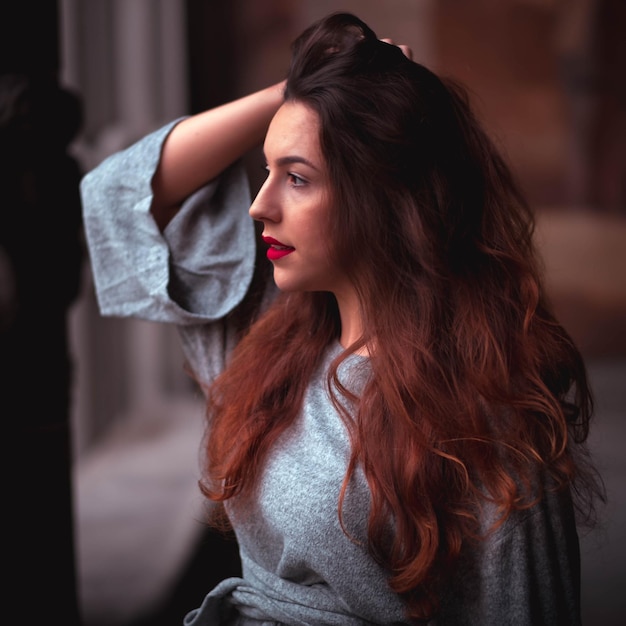 young woman looking away while standing in corridor