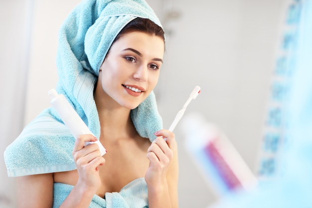 young woman looking in bathroom mirror