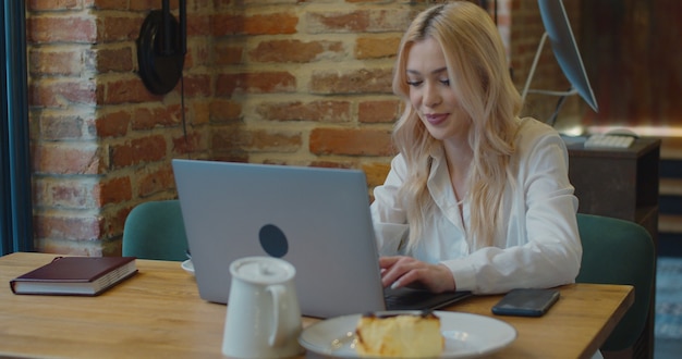 Young woman looking busy working on a laptop at a cafe.