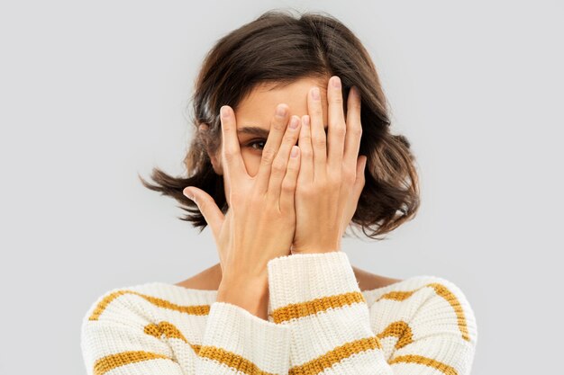 Photo young woman looking by one eye through her fingers