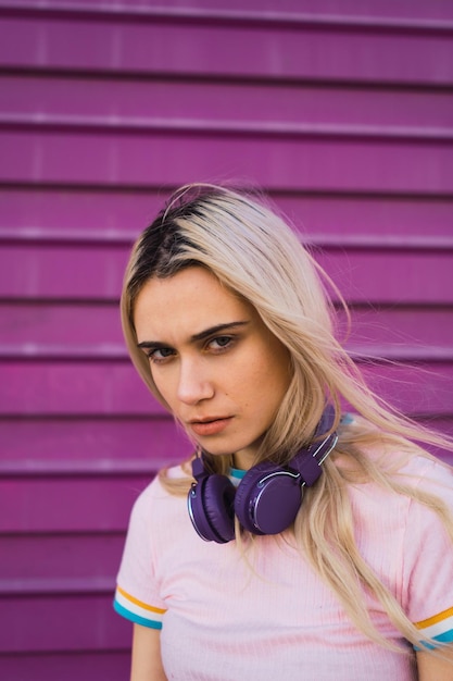 Young woman looking at camera angry with a purple background .