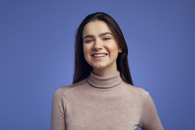 Young woman looking at camera with joyful and charming smile