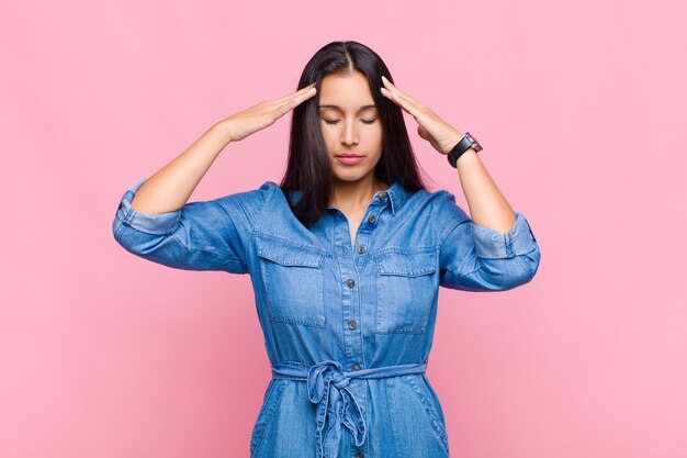 Young woman looking concentrated, thoughtful and inspired