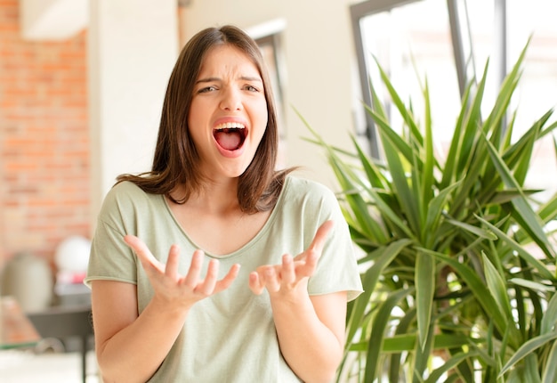 Young woman looking desperate and frustrated stressed unhappy and annoyed shouting and screaming