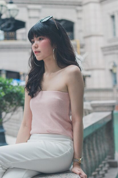 Photo young woman looking down while sitting outdoors