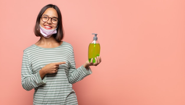 Young woman looking excited and surprised pointing to the side and upwards to copy space