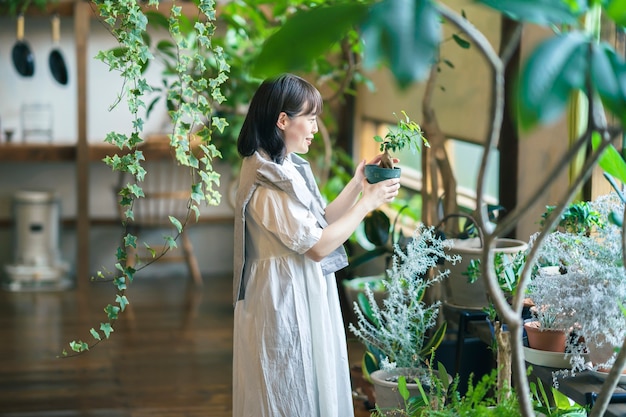 笑顔で観葉植物を見ている若い女性