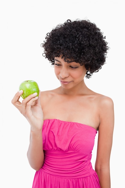Молодая женщина, глядя на ее вкусное зеленое яблоко