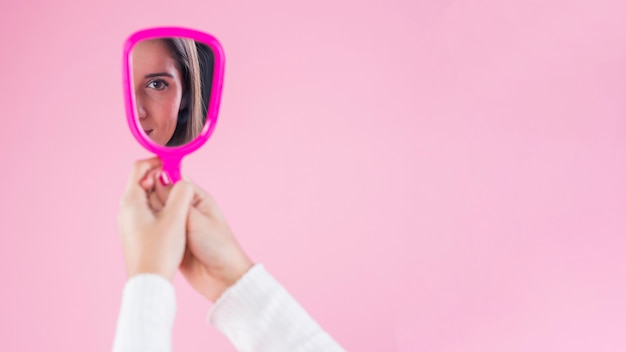 Foto giovane donna guardando se stessa nello specchio