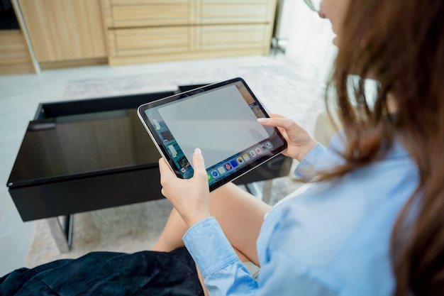 Young woman looking at home security cameras on tablet computer