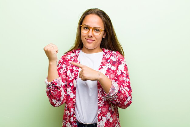 Young woman looking impatient and angry, pointing at watch, asking for punctuality, wants to be on time