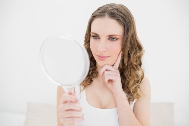 Young woman looking into a mirror