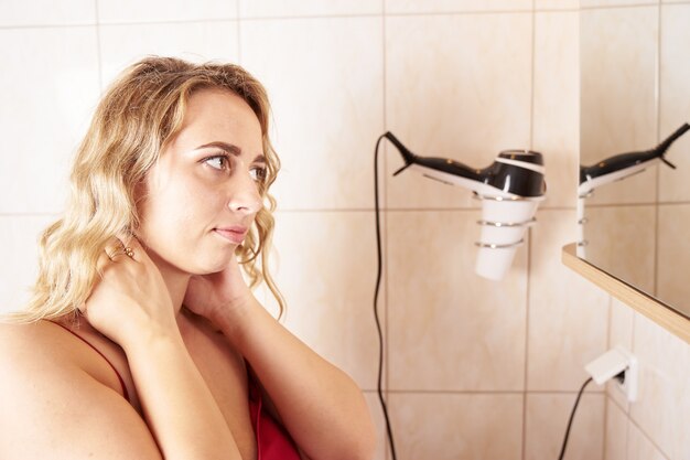 Young woman looking into mirrow during morning routine