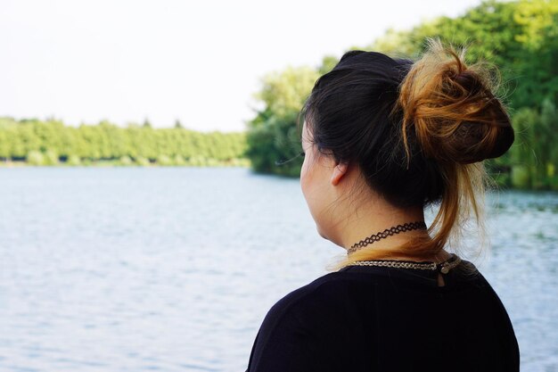 Foto giovane donna che guarda il lago