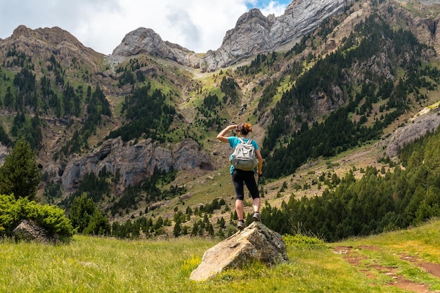 ピレネーアルトガジェゴウエスカで夏の山の風景を見ている若い女性