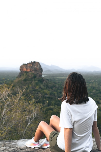 Foto giovane donna che esamina lion rock nello sri lanka