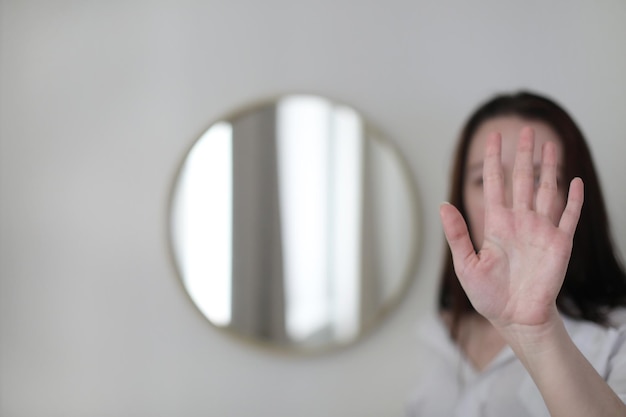 Young woman looking in the mirror Mental health problems in selfisolation at home Depression anxiety phobia suicide and mental health concept