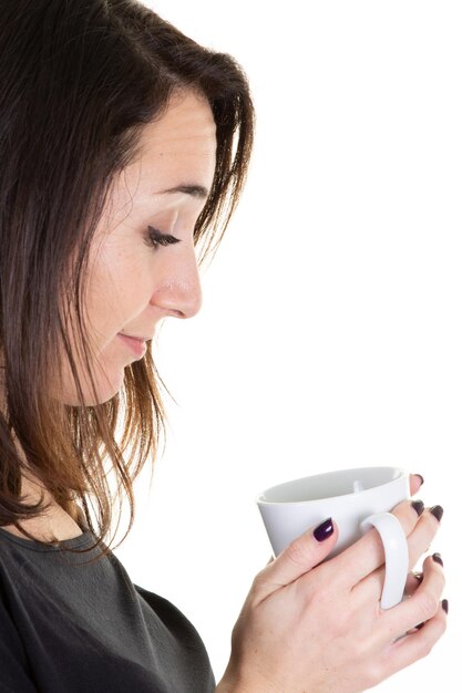 Young woman looking mug coffee tea cup in closeup portrait on white background