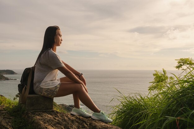 空に反して海を見ている若い女性