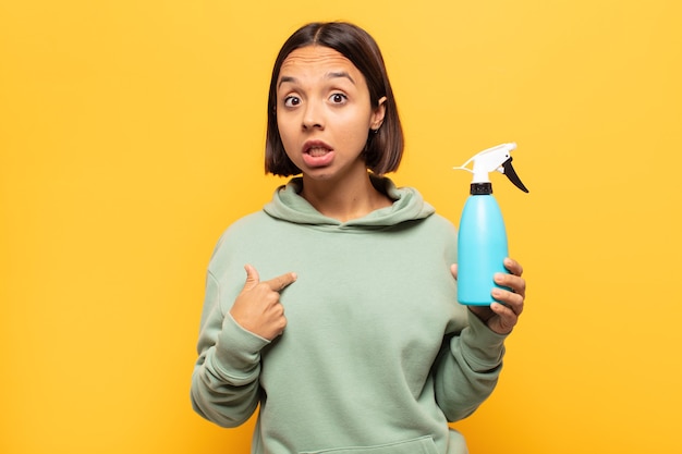 Young woman looking shocked and surprised with mouth wide open, pointing to self