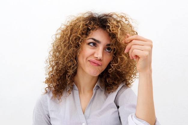 Young woman looking at split ends in hair