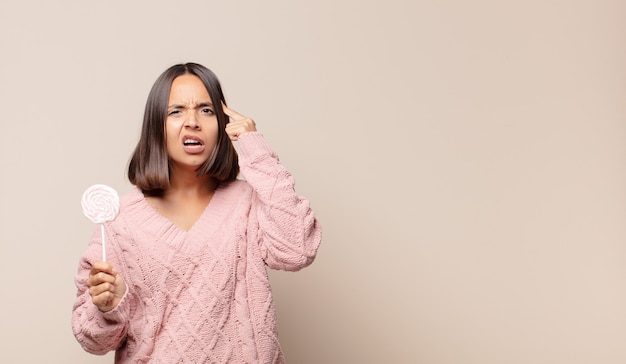 Young woman looking surprised, open-mouthed, shocked, realizing a new thought, idea or concept