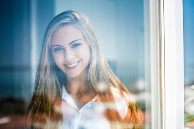 Young woman looking through the window