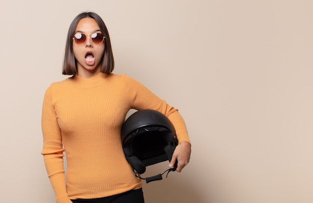 Young woman looking very shocked or surprised, staring with open mouth saying wow