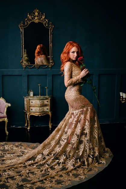 Young woman in luxurious dress standing in vintage interior