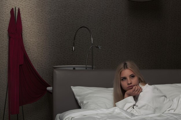 Foto giovane donna sdraiata a letto a casa