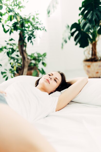 young woman lying on bed at home