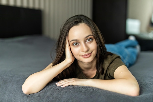 Young woman lying in bed at home