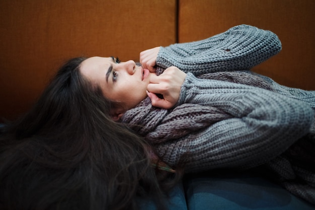 Foto giovane donna sdraiata sul letto con la sciarpa.