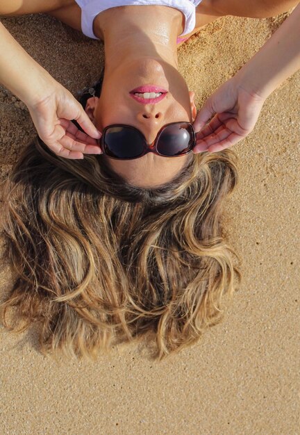 Photo young woman lying down on beach