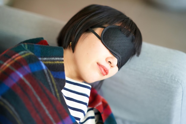 Young woman lying down with an eye mask