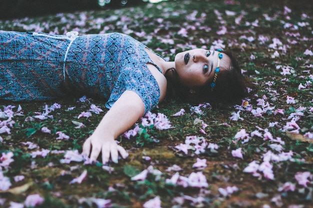 Photo young woman lying on flowers